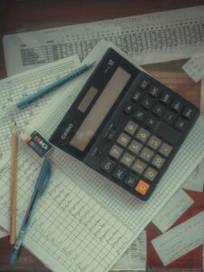 Bookkeeping profession workers using computers and AI technology in modern office showing employment decline trends.
